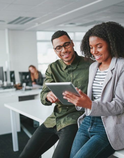 Successful african american business couple talking and using digital tablet
